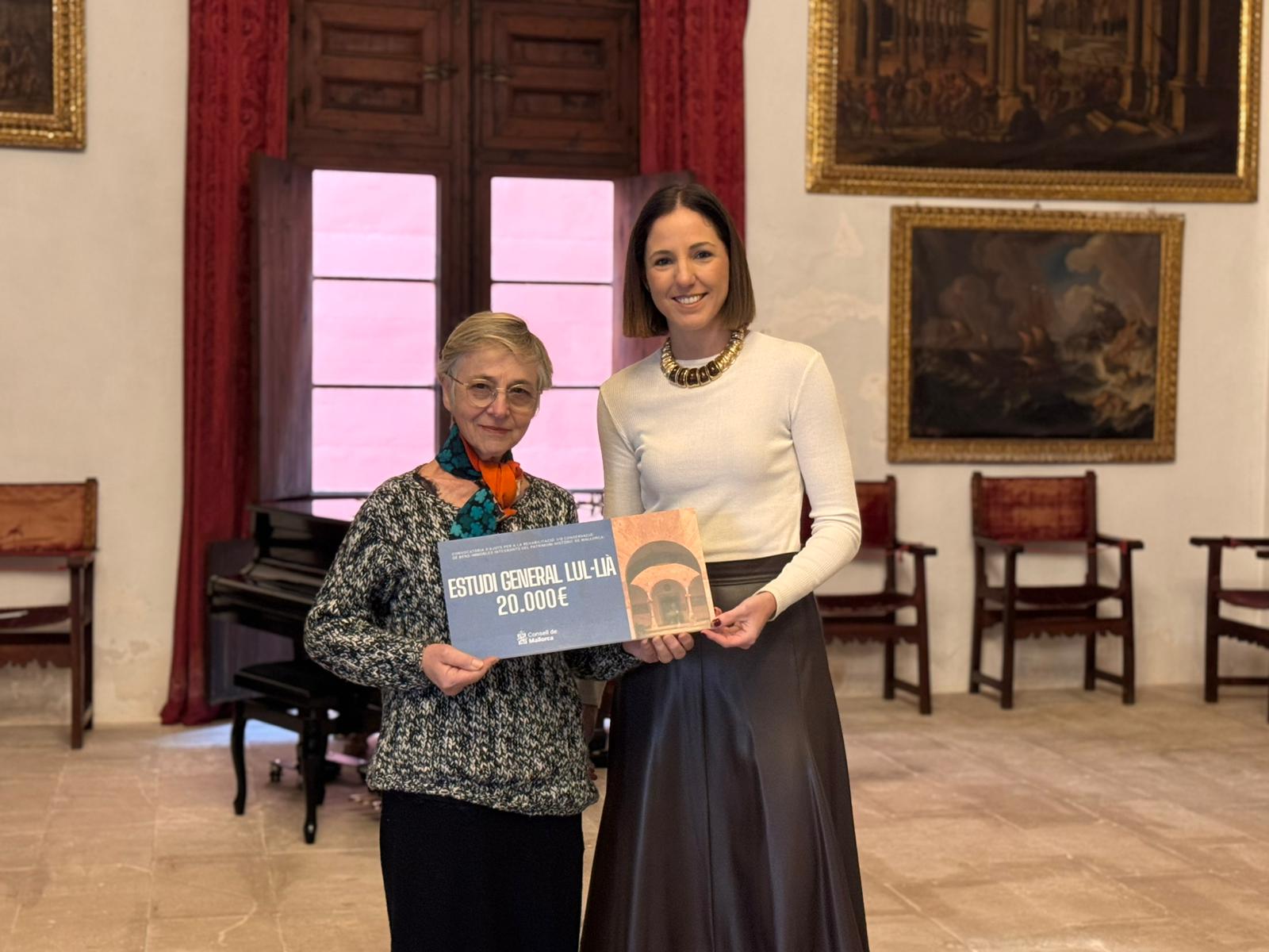 La consejera de Cultura y Patrimonio, Antònia Roca, entrega la subvención a la representante del Estudi General Lul·lià.