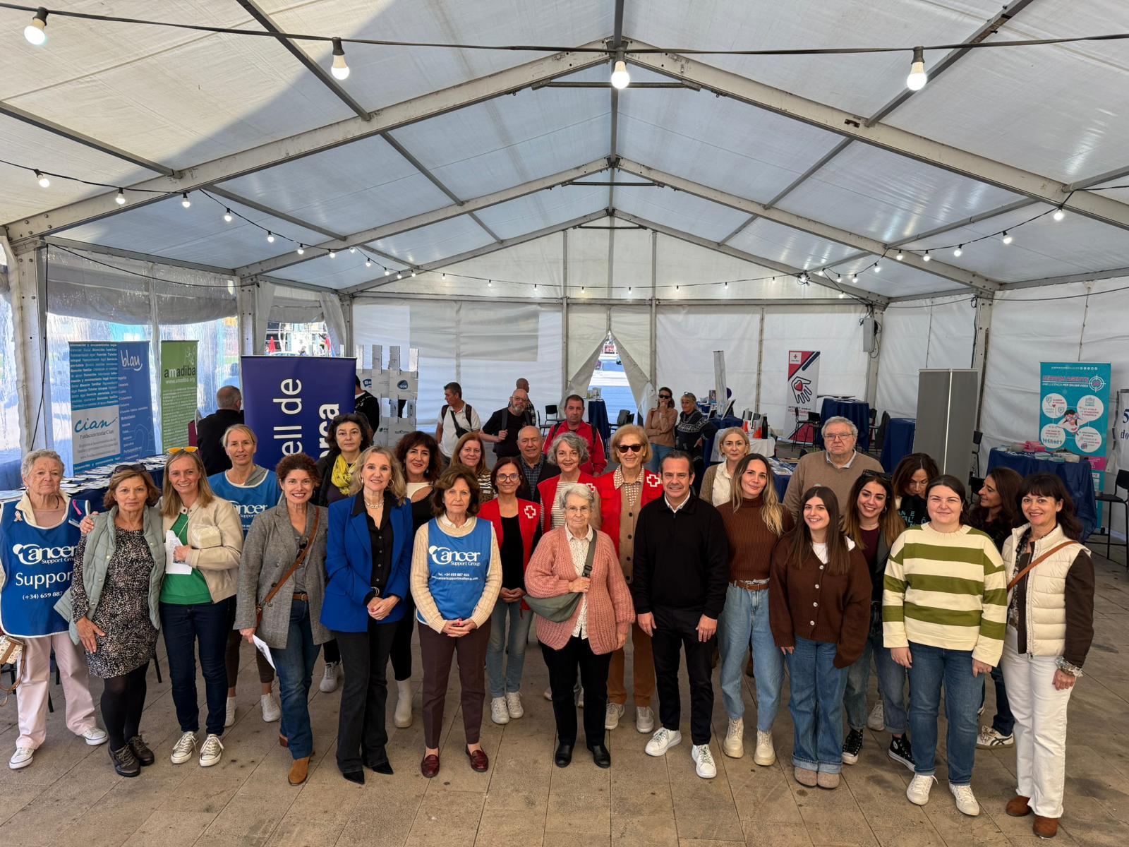 El conseller de Presidència, Antoni Fuster i la directora insular de Joventut i Participació, Carmen Ripoll, amb les diferents entitats solidàries a la Fira del Voluntariat.